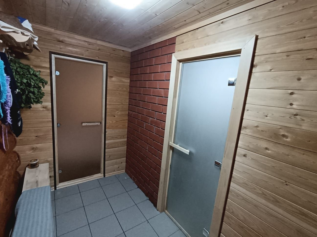 Фото установленной стеклянной двери в парную Также были установлены стеклянные двери для сауны, которые обеспечивают безопасность и не деформируется при высоких температурах.